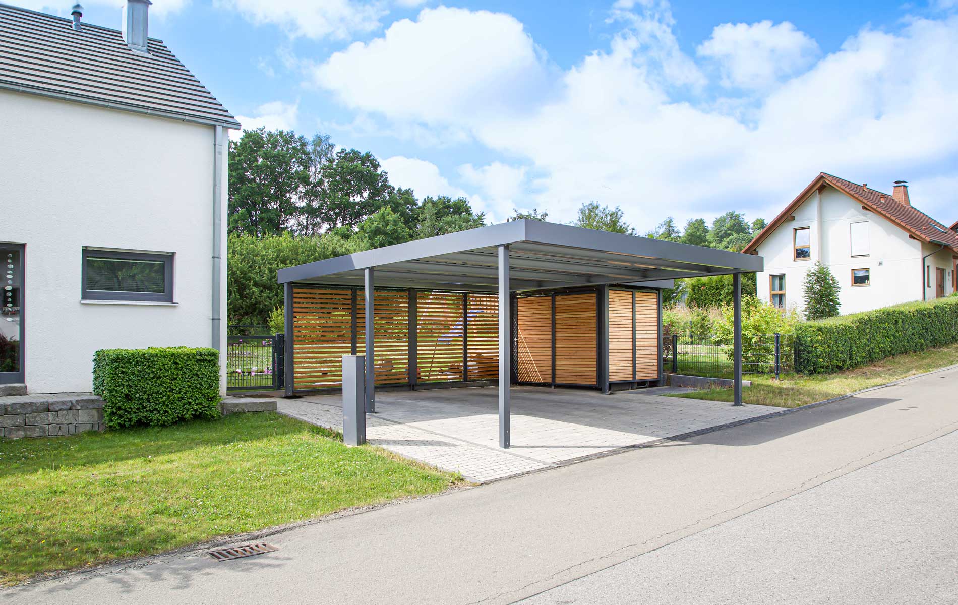 Doppelcarport mit seitlichem Geräteraumanbau aus Sichtschutzelementen